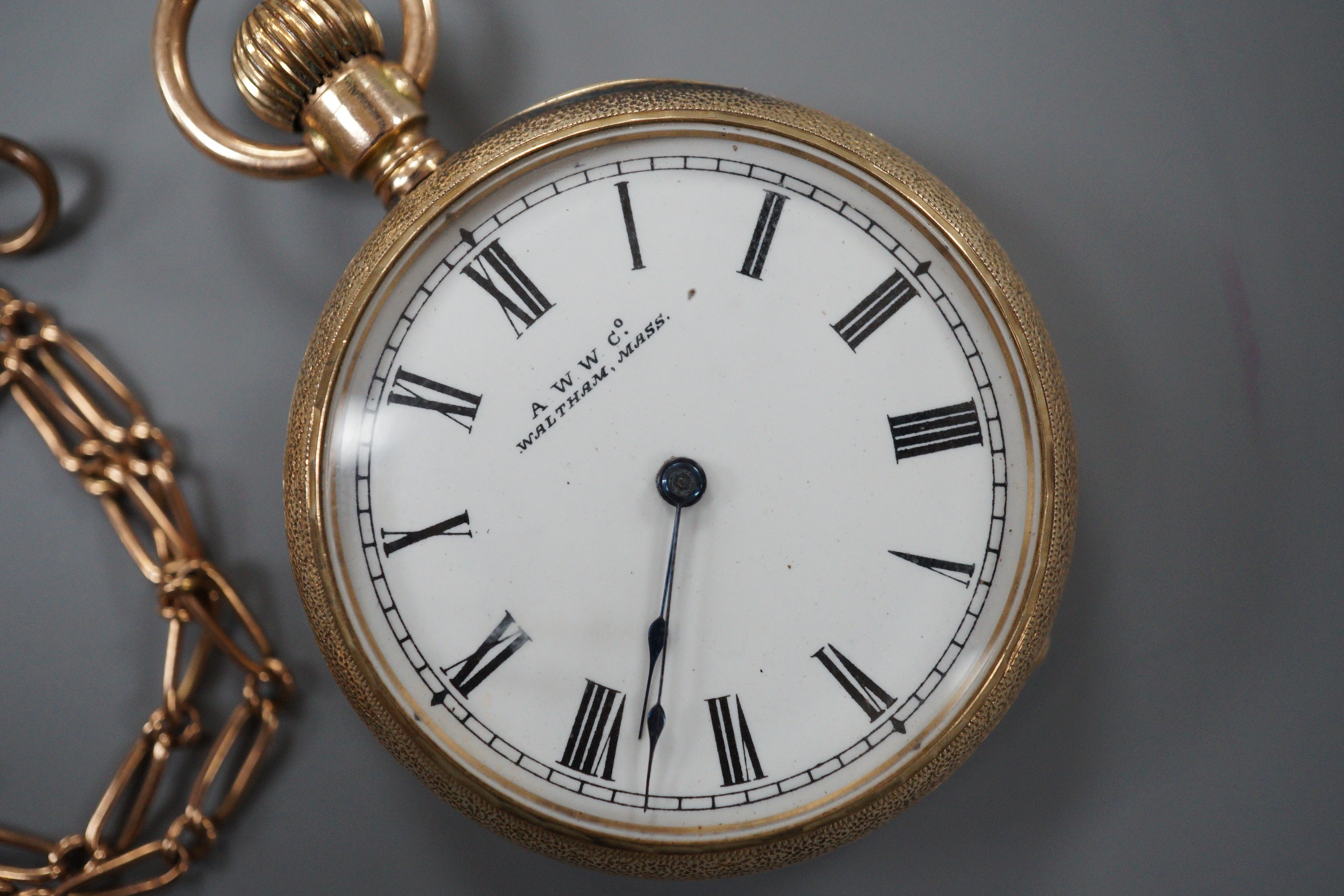 A gentleman’s 10C yellow metal Waltham open faced keyless pocket watch, gross 45.7 grams, on a 9ct gold albert, 6.3 grams.